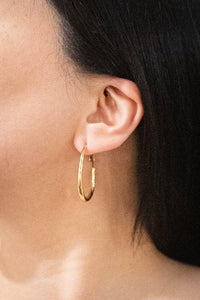 Gold 18K waterproof hoop earrings shown in lifestyle flat-lay