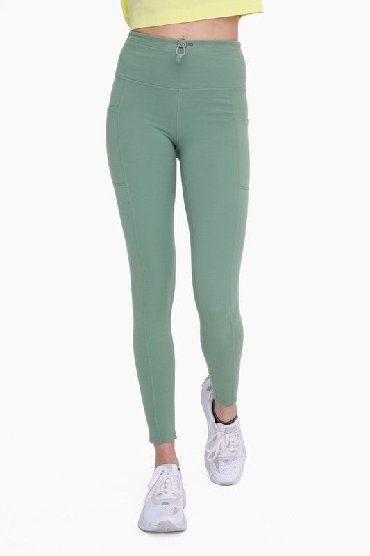 Women's adjustable bungee waist hiking leggings in green, designed for comfort and outdoor adventures