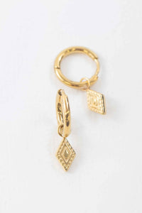 Close up of Dainty Gold dangle huggie hoop earrings on a whitebackground