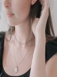 Closeup of minimalist gold pendant necklace with fine chain