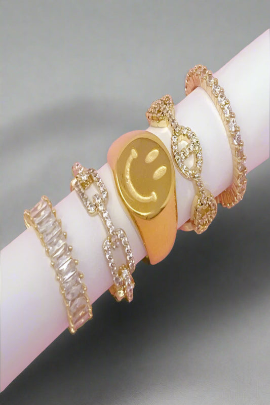 Gold smiley face ring stacked with other dainty rings, for everyday wear