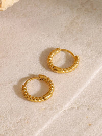 Close-up of twisted 18K gold-plated waterproof huggie earrings